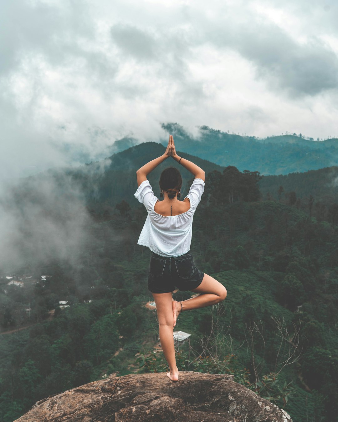 woman-standing-on-rock-facing-forest-dqx4xwuxu7w